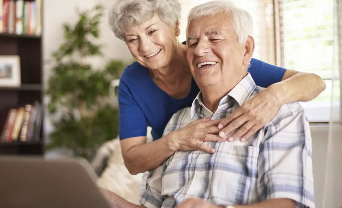 abuelos felices usando su computadora portatil digital